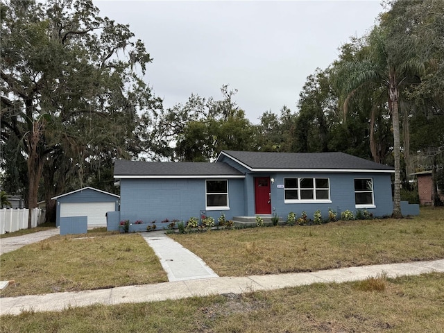 ranch-style house featuring a garage, an outdoor structure, and a front yard