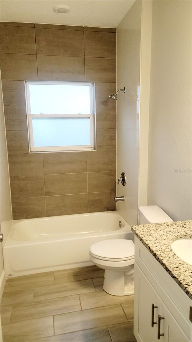 full bathroom featuring toilet, tiled shower / bath, and vanity