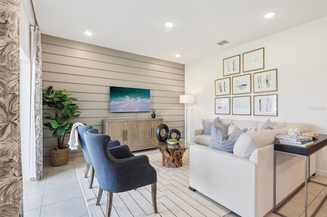 tiled living room featuring wood walls