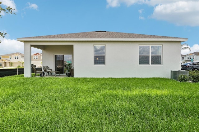 rear view of house with a lawn and central air condition unit