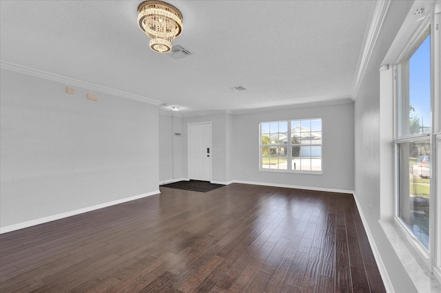 unfurnished living room featuring baseboards, visible vents, dark wood-style flooring, crown molding, and a chandelier