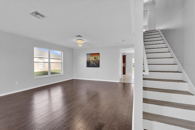 unfurnished living room featuring visible vents, a textured ceiling, and wood finished floors