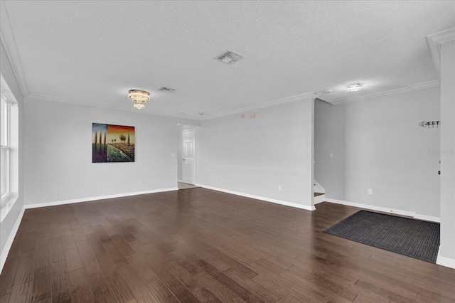 unfurnished living room featuring baseboards, visible vents, dark wood-type flooring, a textured ceiling, and crown molding