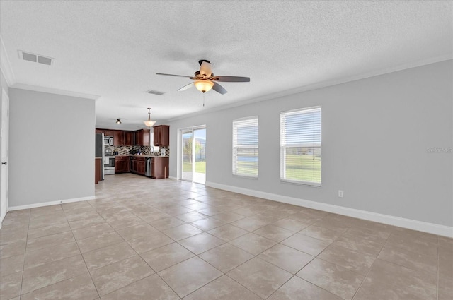 unfurnished living room with baseboards, a ceiling fan, visible vents, and ornamental molding