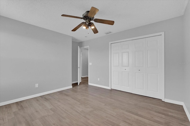 unfurnished bedroom featuring wood finished floors, visible vents, and baseboards