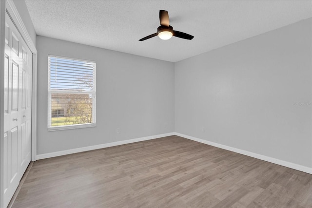 unfurnished bedroom featuring a closet, baseboards, and wood finished floors