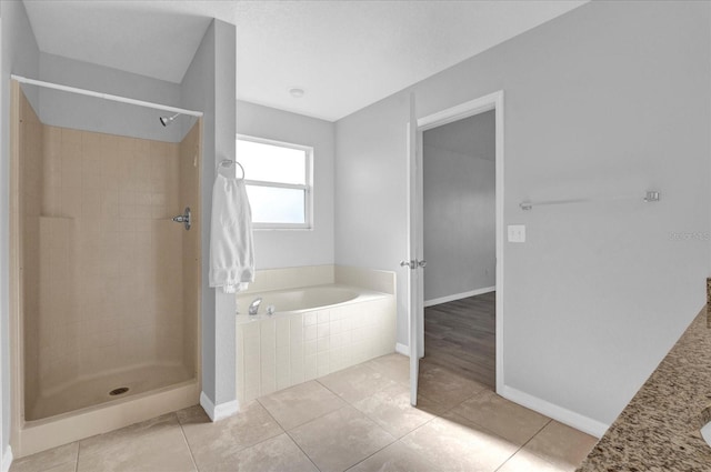 full bathroom featuring tile patterned floors, a garden tub, baseboards, and a tile shower