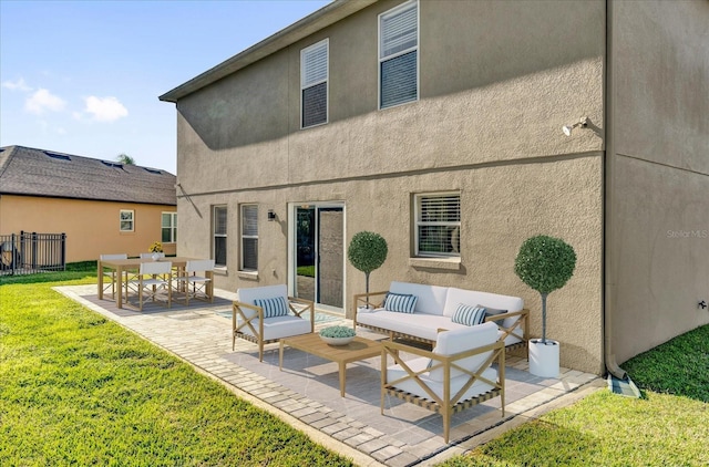 rear view of house featuring stucco siding, fence, a yard, outdoor lounge area, and a patio area