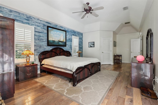 bedroom featuring hardwood / wood-style floors, vaulted ceiling, and ceiling fan