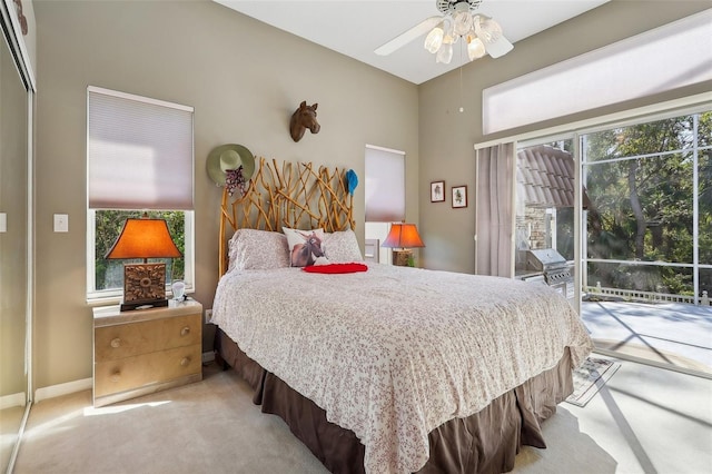 bedroom featuring multiple windows, light colored carpet, ceiling fan, and access to outside