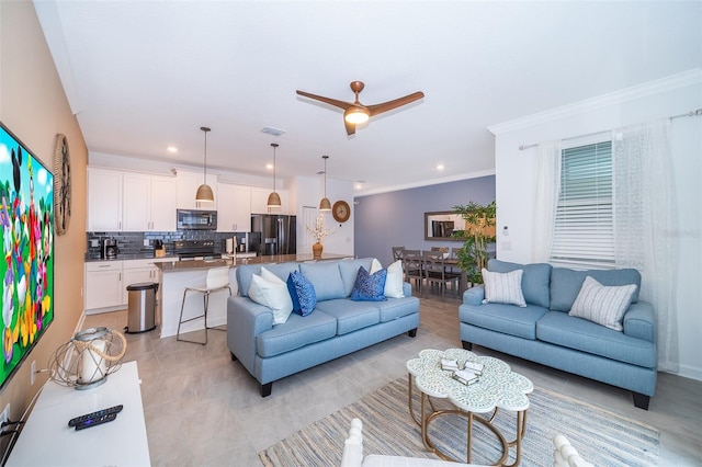 living room with ceiling fan and ornamental molding