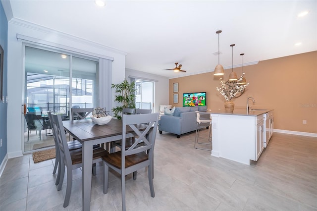 dining space featuring sink, ceiling fan, and crown molding