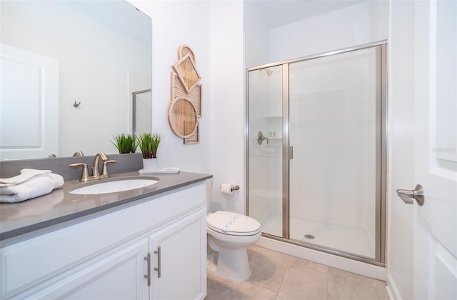 bathroom featuring toilet, walk in shower, vanity, and tile patterned flooring