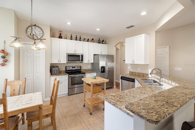 kitchen featuring pendant lighting, sink, white cabinetry, and appliances with stainless steel finishes