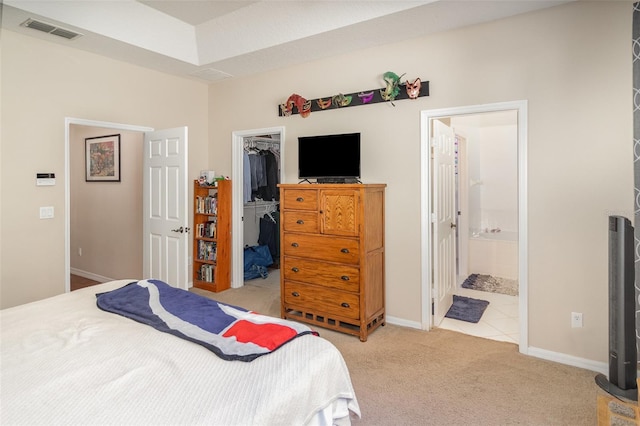 carpeted bedroom with ensuite bathroom, a walk in closet, and a closet