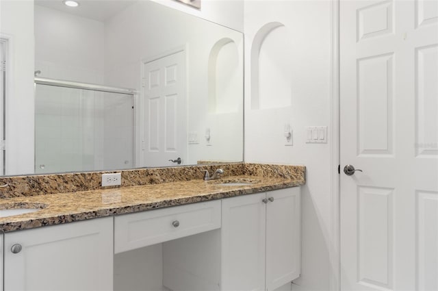 bathroom with vanity and a shower with shower door