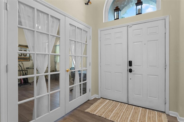 entrance foyer featuring baseboards, wood finished floors, and french doors