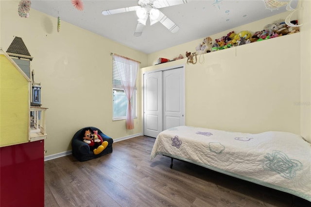 bedroom with ceiling fan, dark wood-type flooring, a closet, and baseboards