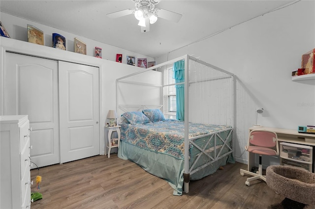 bedroom featuring lofted ceiling, light wood-style flooring, a ceiling fan, and a closet