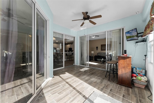 sunroom / solarium featuring a ceiling fan