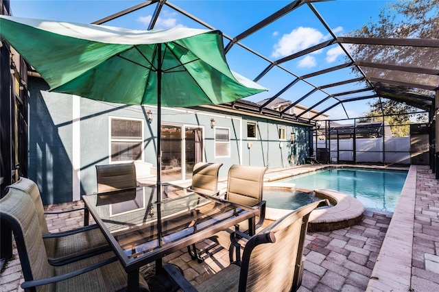 view of pool with a pool with connected hot tub, glass enclosure, and a patio