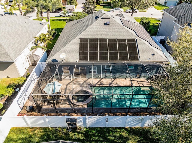 exterior space featuring a shingled roof, a lanai, and solar panels