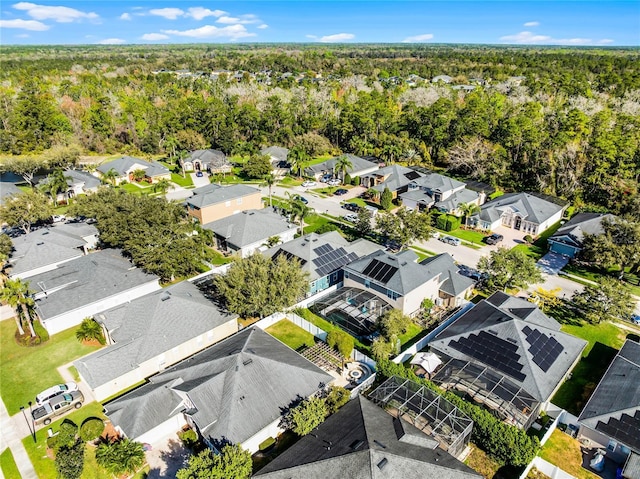 drone / aerial view featuring a residential view and a view of trees