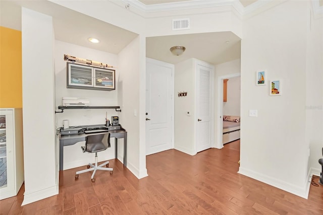 interior space featuring wood-type flooring and ornamental molding