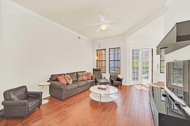 living room featuring hardwood / wood-style flooring, ceiling fan, and ornamental molding