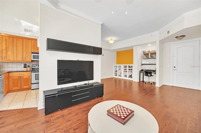 living room featuring crown molding and light wood-type flooring