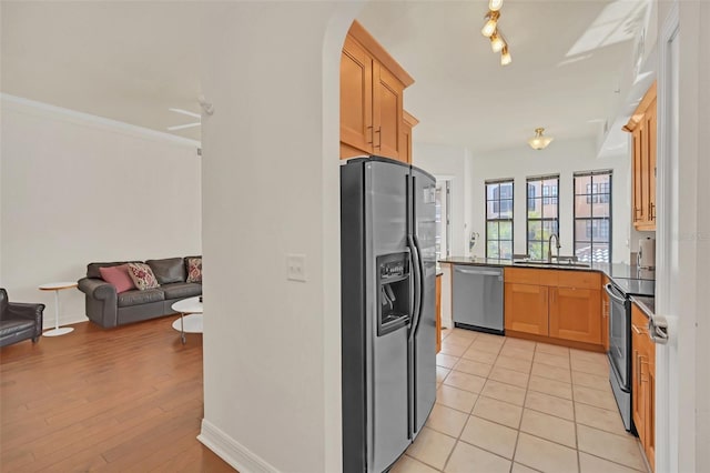 kitchen with sink, light tile patterned floors, stainless steel appliances, ornamental molding, and light brown cabinets