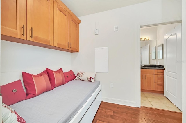 bedroom with ensuite bath and light hardwood / wood-style flooring