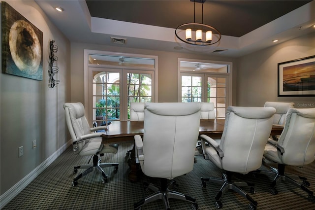 carpeted office space featuring a tray ceiling, a chandelier, and french doors