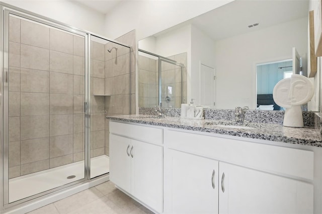 bathroom featuring a shower with shower door, vanity, and tile patterned flooring