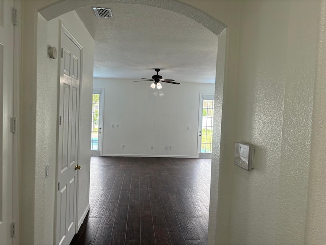 spare room with ceiling fan, dark wood-type flooring, and a textured ceiling