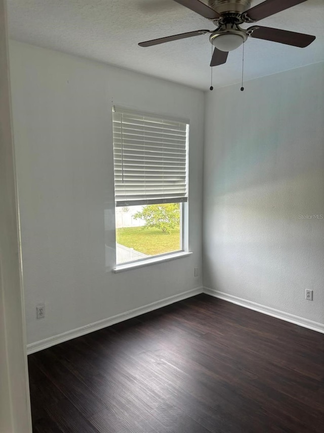 spare room with ceiling fan and dark hardwood / wood-style flooring