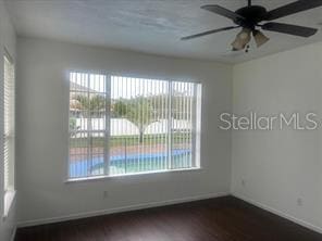 unfurnished room featuring ceiling fan and dark wood-type flooring