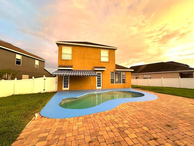 pool at dusk with a patio area