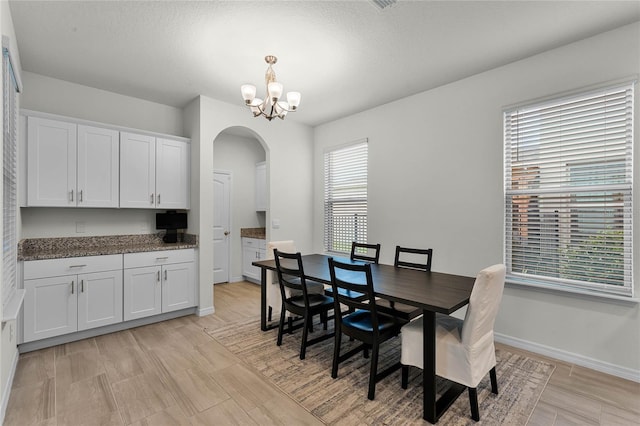 dining space featuring an inviting chandelier and a textured ceiling