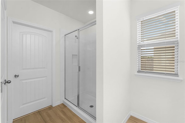 bathroom featuring hardwood / wood-style flooring and an enclosed shower