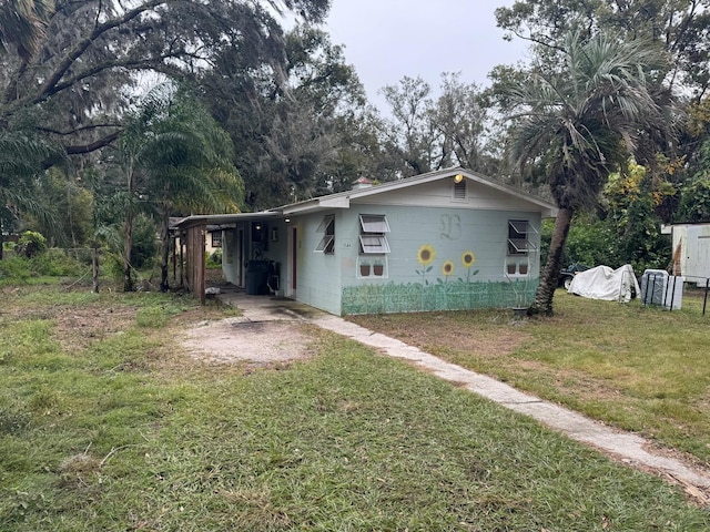 view of front of house featuring a front lawn and a carport