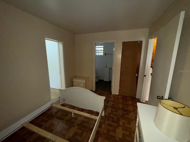 bedroom featuring connected bathroom and dark parquet floors