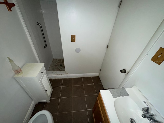 bathroom featuring sink, tile patterned floors, walk in shower, and toilet