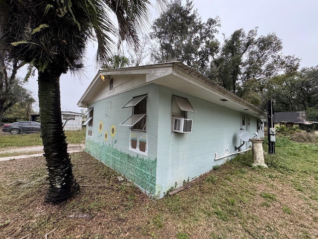 view of home's exterior with cooling unit and a yard