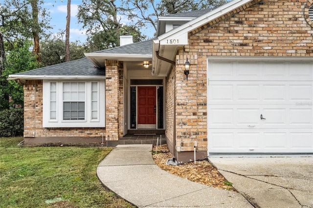 view of exterior entry featuring a garage and a yard