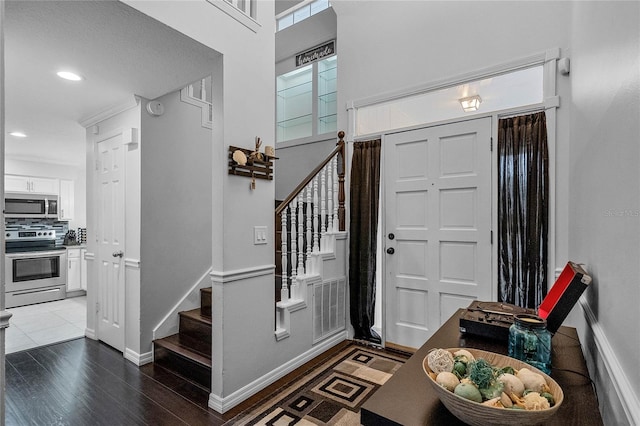 entryway featuring ornamental molding and dark hardwood / wood-style flooring