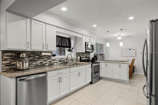 kitchen with decorative light fixtures, kitchen peninsula, white cabinets, and appliances with stainless steel finishes