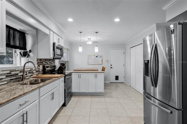 kitchen with pendant lighting, sink, stainless steel appliances, white cabinets, and kitchen peninsula