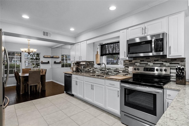 kitchen featuring sink, crown molding, decorative light fixtures, stainless steel appliances, and white cabinets