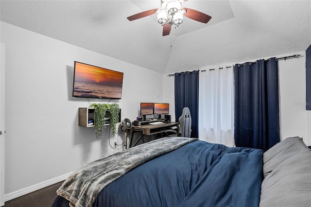 bedroom with ceiling fan, lofted ceiling, wood-type flooring, and a textured ceiling